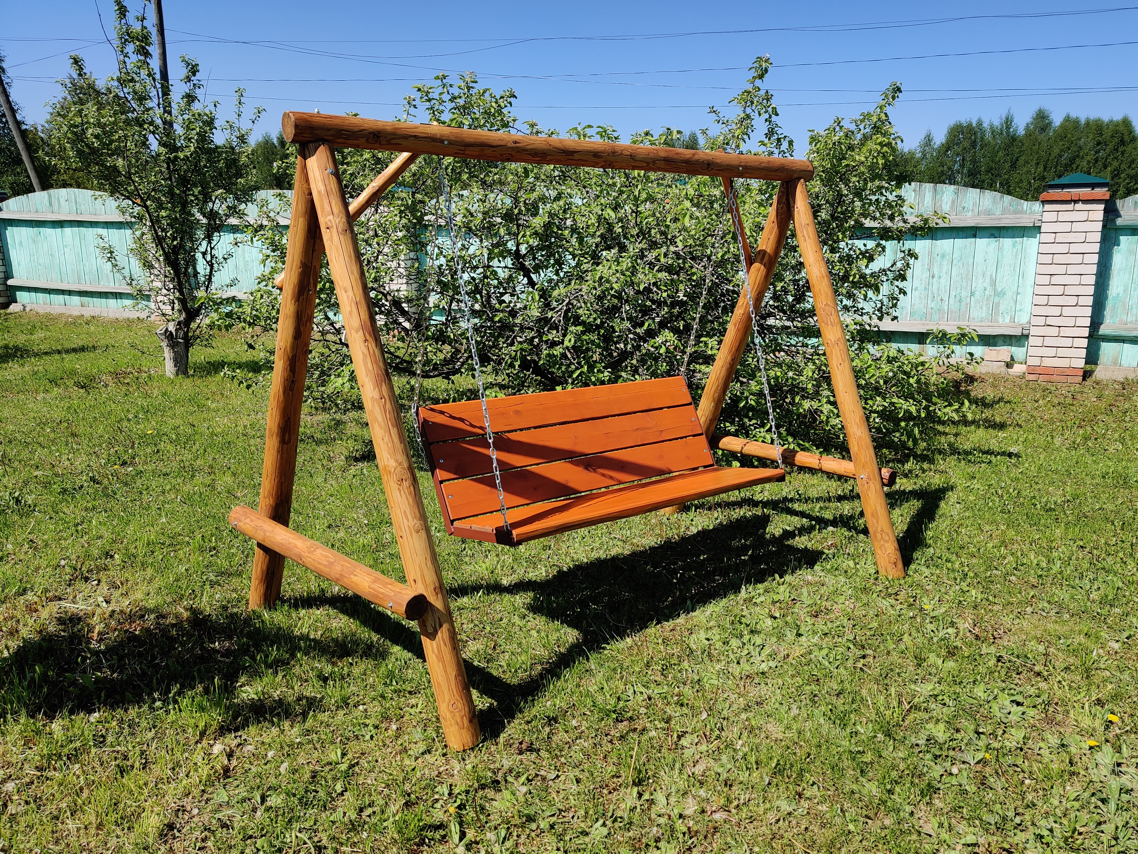 Деревянные качели в саду